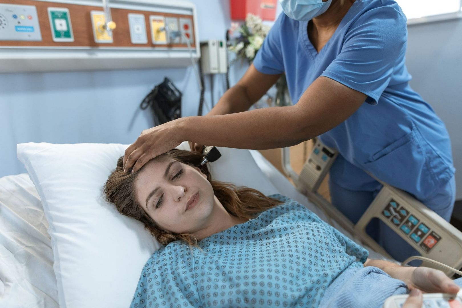 Pflegekraft unterstützt eine Patientin im Krankenhausbett