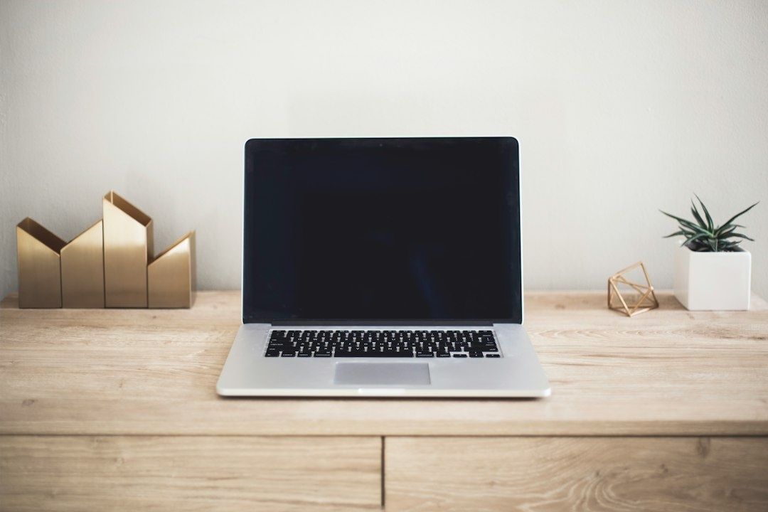 Laptop auf einem aufgeräumten Holztisch als Symbol für konzentriertes Arbeiten